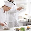 Female chef decorating cookies with chocolate.